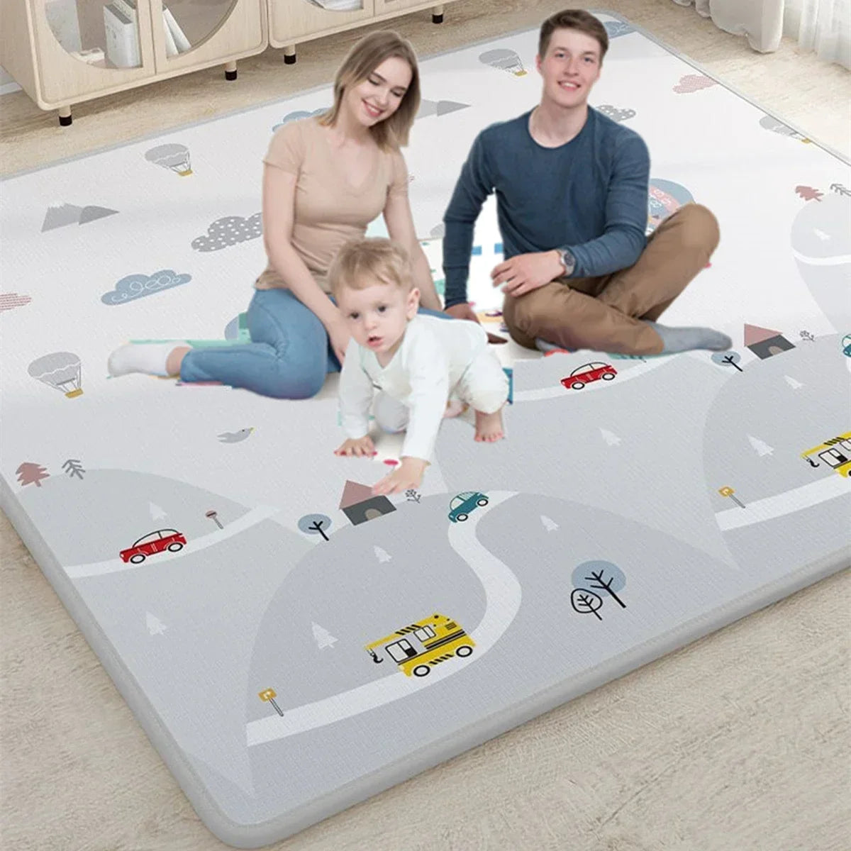 Family sitting on a large play mat with road and vehicle designs in a room.