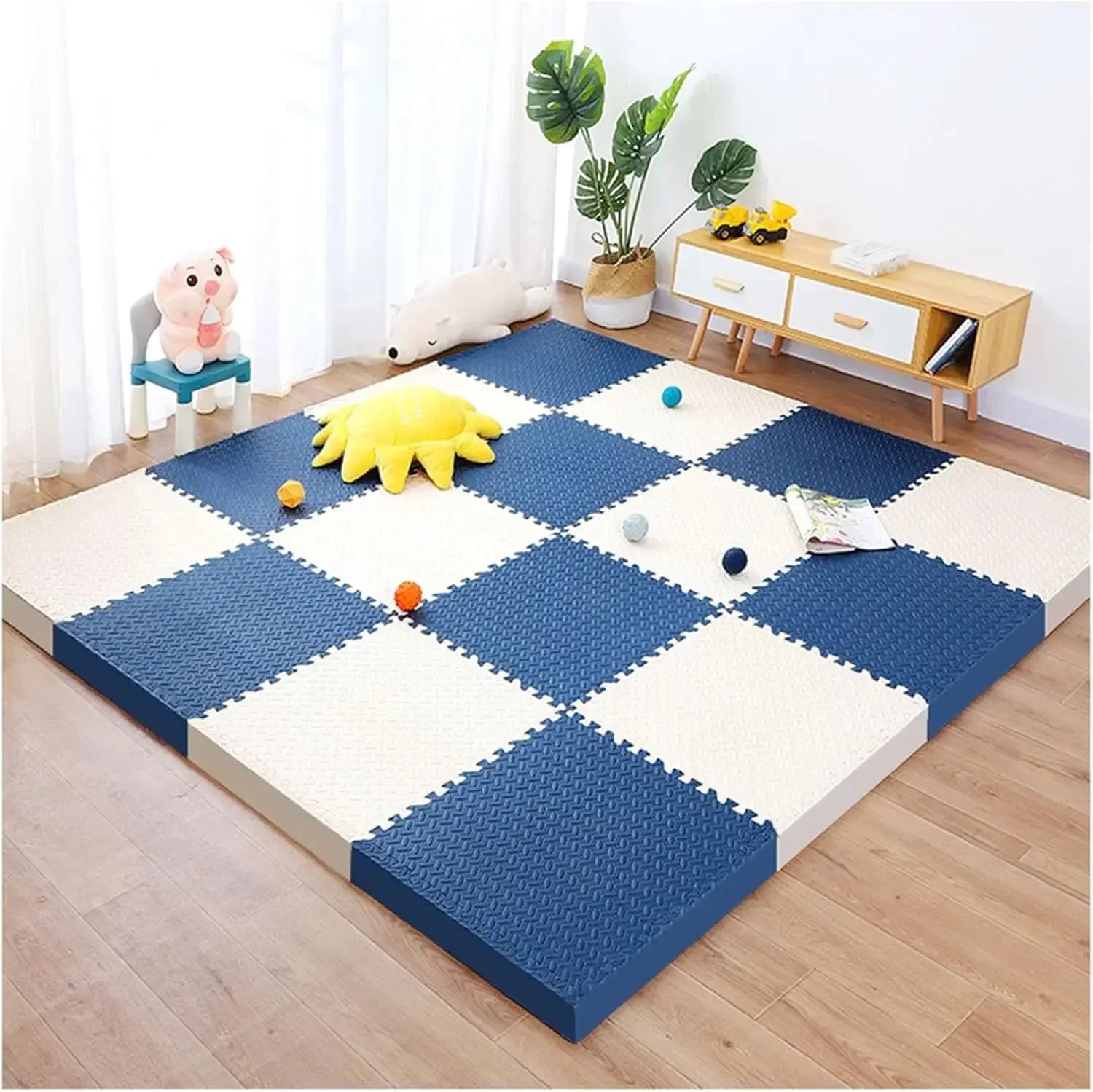 Children's play area with blue and white foam mats on a wooden floor.