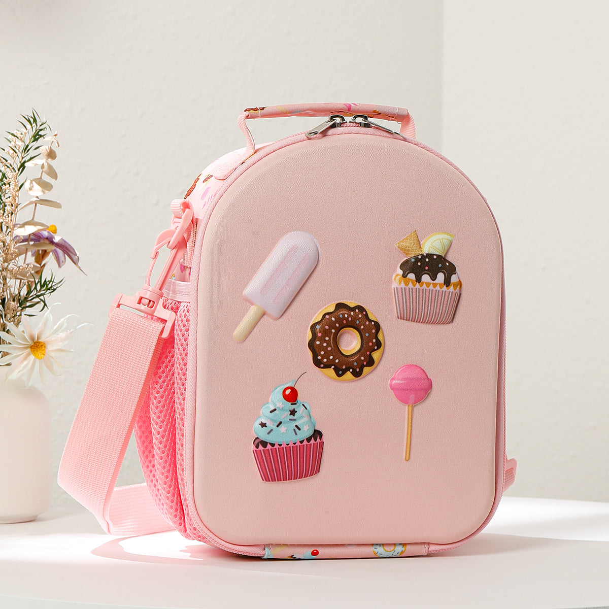 Pink lunch bag with dessert-themed decorations on a light background