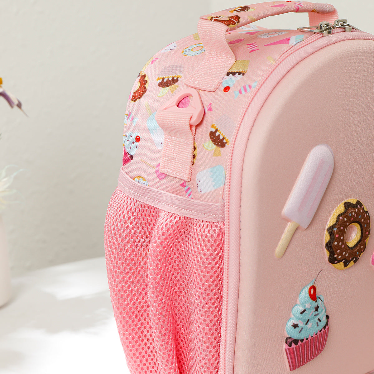 Pink children's lunch bag with ice cream and donut designs on a white background
