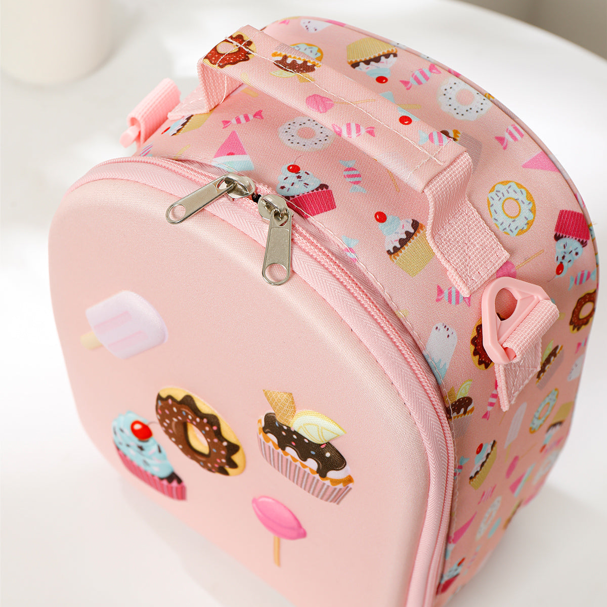 Pink cosmetic bag with dessert pattern on a white background